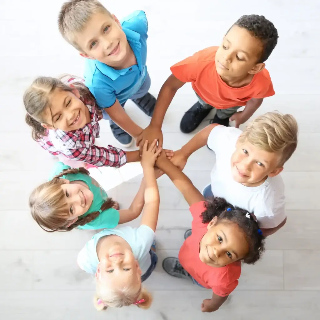 Little Children putting their hands together in a circle